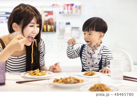 Mother and son in the kitchen, eating noodles Mother and son in the kitchen, eating noodles 48465780