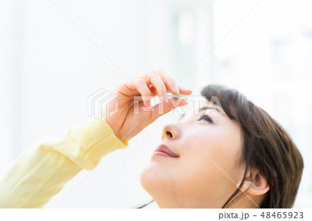 目薬をさす若い女性  女の子  ライフスタイル 女性ポートレート 48465923