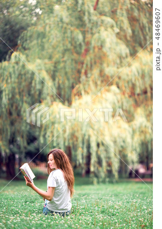 Relaxed young woman reading book 48469607
