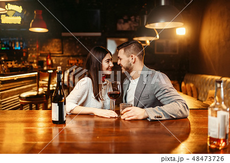 Romantic evening in bar, couple kissing at counter 48473726