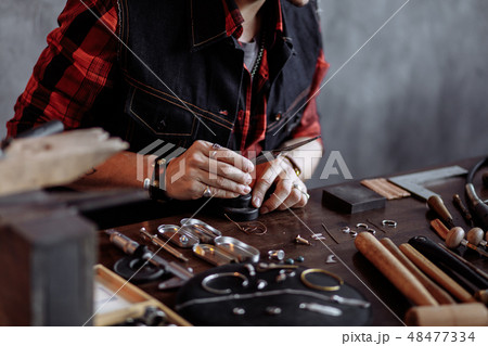 gorgeous creative man flattening and shaping metals and jewelries. gorgeous creative man flattening and shaping metals and jewelries. 48477334