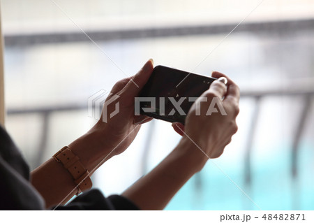 携帯で動画を見る女性の画像 携帯で動画を見る女性の画像 48482871