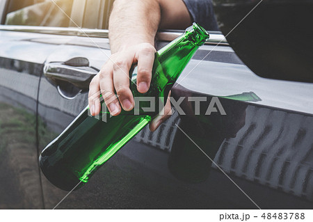 Close up of bottle, Young asian man drives a car with drunk a bo Close up of bottle, Young asian man drives a car with drunk a bo 48483788