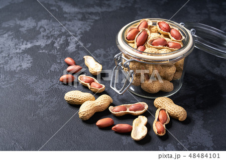 Peanut in an open glass jar on a black table. Peanut in an open glass jar on a black table. 48484101