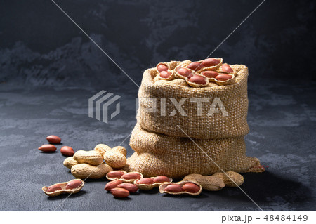 Peanuts in bag on black table. Peanuts in bag on black table. 48484149
