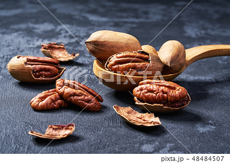 Pecan in wooden spoon on black table, close-up. 48484507
