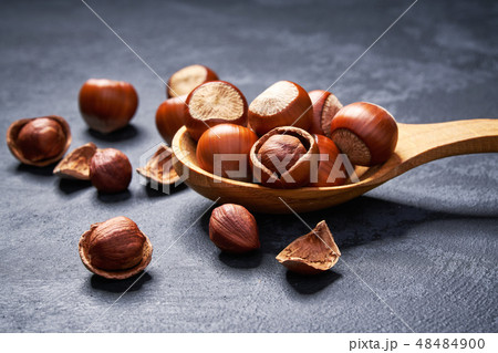 Hazelnut in wooden spoon on black table 48484900
