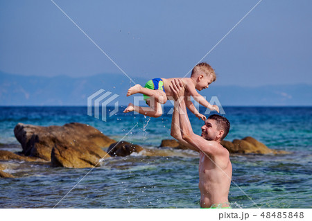 Toddler boy on beach with father Toddler boy on beach with father 48485848