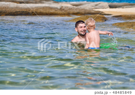 Toddler boy on beach with father Toddler boy on beach with father 48485849