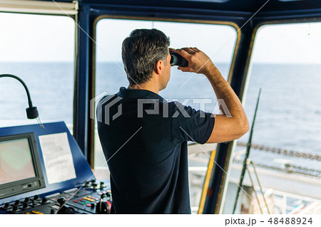 Officer during navigational watch looking through binoculars 48488924