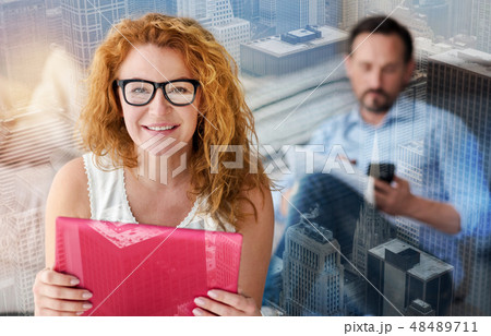 Lovely smiling woman enjoying her new convenient gadget 48489711