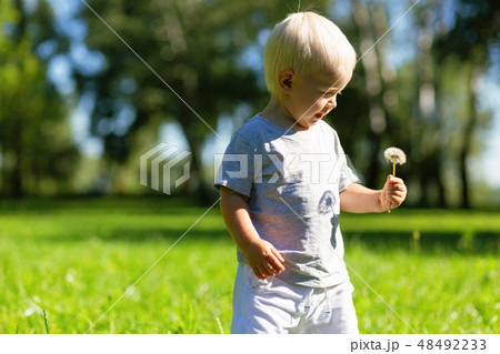 Happy kid holding a flower in the hand Happy kid holding a flower in the hand 48492233