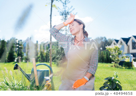 Professional gardener feeling under the weather after working on hot day 48494658