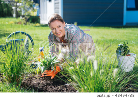 Great supporter of clean environment spending her morning near flower bed Great supporter of clean environment spending her morning near flower bed 48494738