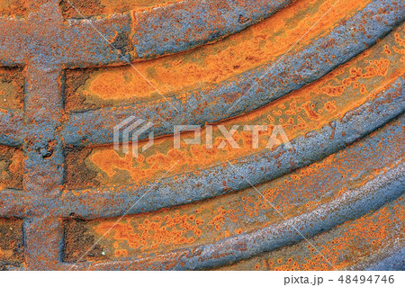 Fragment of an old rusty manhole cover. Closeup. 48494746