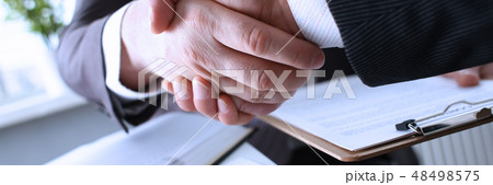 Man in suit shake hand as hello in office Man in suit shake hand as hello in office 48498575