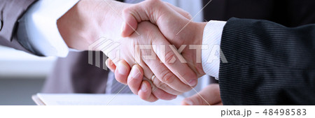 Man in suit shake hand as hello in office Man in suit shake hand as hello in office 48498583