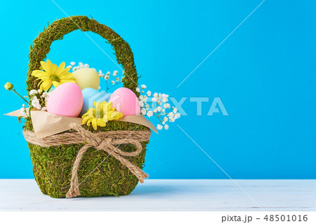 Colorful easter eggs in backet on blue background 48501016