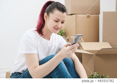 Young beautiful girl with colored hair in a white T-shirt and jeans, talking on the phone and writes Young beautiful girl with colored hair in a white T-shirt and jeans, talking on the phone and writes 48503782