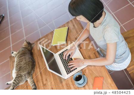 working at home with her cat 48504425
