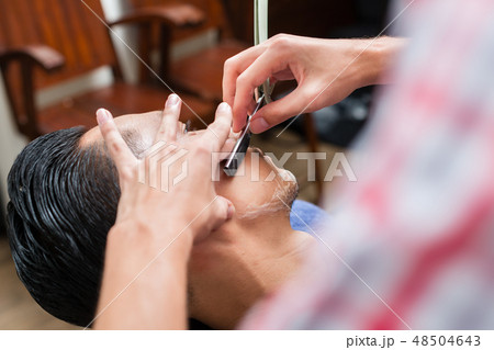 Barber shaving with straight razor Barber shaving with straight razor 48504643