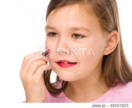 Little girl is applying lipstick on her cheek Little girl is applying lipstick on her cheek 48507855