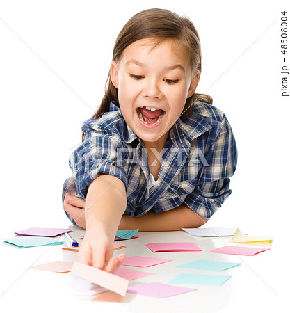 Girl is writing on color stickers using pen Girl is writing on color stickers using pen 48508004