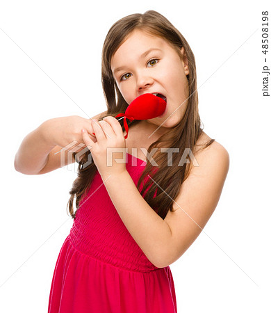 Portrait of a little girl biting red heart Portrait of a little girl biting red heart 48508198