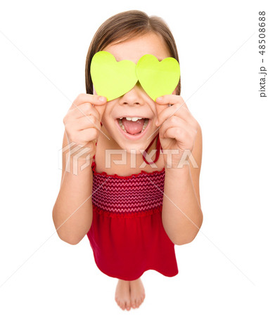 Little girl is holding hearts over her eyes 48508688