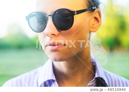Portrait of a Young Woman in Sunglasses in Foliage 48510940