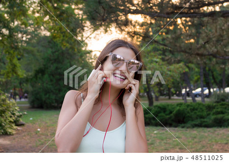 Pretty girl is listening to music in headphones 48511025