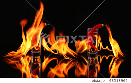 Hot chili pepper in a shot  glass with a fire 48513965