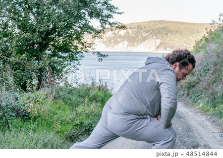Fat man doing warm-up in nature Fat man doing warm-up in nature 48514844