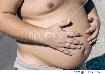 Fat man with big belly standing on the ocean 48514870