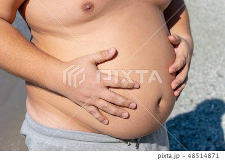 Fat man with big belly standing on the ocean 48514871