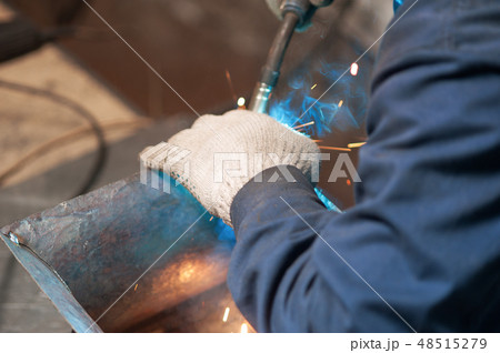 Blacksmith soldering a metal plate in workshop 48515279