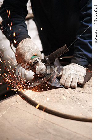 Close up of blacksmith grindering a metal plate 48515324