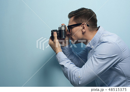 Young male photographer holding a new camera Young male photographer holding a new camera 48515375