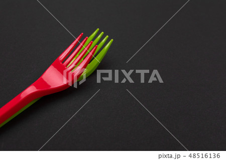 Disposable red and green plastic forks isolated on background Disposable red and green plastic forks isolated on background 48516136