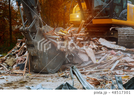 old house being demolished by a large backhoe old house being demolished by a large backhoe 48517301