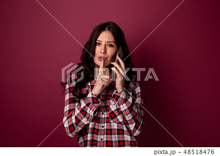 Photo of a nice woman showing to keep silence and talking phone. 48518476