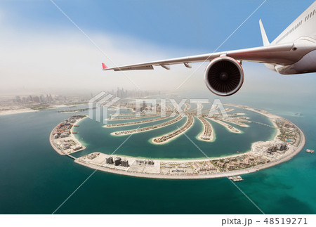 Commercial jet plane flying above Dubai city. 48519271