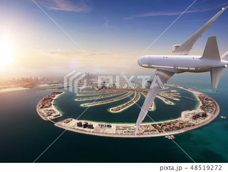 Commercial jet plane flying above Dubai city. 48519272