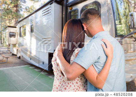 Young Couple Embrace In Front of New RV Young Couple Embrace In Front of New RV 48520208