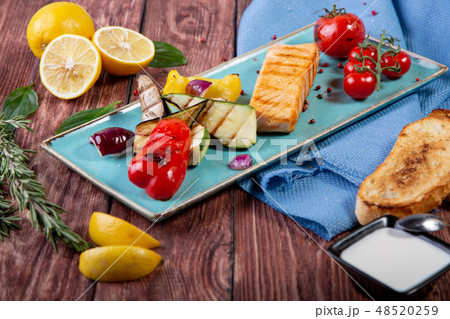 Grilled salmon served with grilled vegetables - top view Grilled salmon served with grilled vegetables - top view 48520259