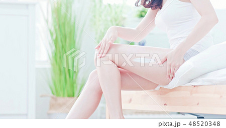 Woman apply cream onto her leg 48520348