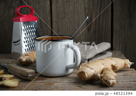 Healthy ginger tea cup, ginger root and grater. 48521394