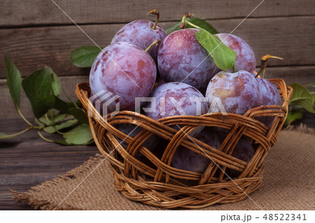 plum in a wicker basket on the wooden background with sackcloth plum in a wicker basket on the wooden background with sackcloth 48522341