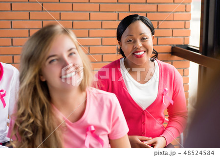 Multiethnic group of women meeting for breast cancer awareness c Multiethnic group of women meeting for breast cancer awareness c 48524584