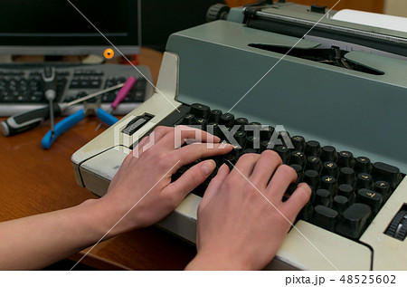 Hands of a girl on the buttons of an typewriter 48525602